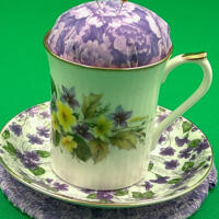 This shows the pincushion with the saucer aka bobbin holder sitting on top of the trivet. It's about 5 inches high by 5.5 inches wide.