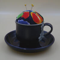 Looking at the front of the pincushion/bobbin holder, it's easy to see the lace on the mug and the colors of the flower of the pincushion. Looking at the front of the pincushion/bobbin holder, it's easy to see the lace on the mug and the colors of the flower of the pincushion.