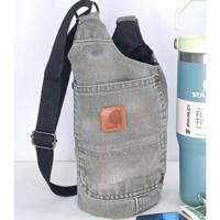 Upcycled Carhartt canvas water bottle sling shown beside Stanley tumbler and essentials.