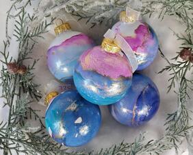 set of 5 painted glass ornaments in pink, blue and gold.