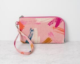 This wristlet using a funky pink with pops of color canvas print, is perfect to carry by itself on in a bigger purse. It comes with two card slots inside and a zipper pocket for coins. The zipper wraps around two sides, which makes it easy to access and see what's inside.