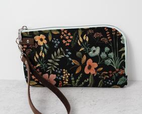 This wristlet using a cute floral canvas print, is perfect to carry by itself on in a bigger purse. It comes with two card slots inside and a zipper pocket for coins. The zipper wraps around two sides, which makes it easy to access and see what's inside.