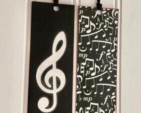 Glossy black and silver metallic combination produced a Treble Clef  double sized bookmark. Made of cardstock and laminated Measurement 2.25" W x 6:" L.  We also offer Native American Dream Catcher and a delicate tan card stock with music note and music stand. We offer uniesex bookmarks.
