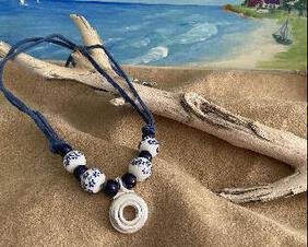 This necklace has large white beads with lovely blue flowers and navy bluye solid beards but, it is a larger version of the trill key necklace with flowers..  A Silver open hole flute key is the pendant of choice.