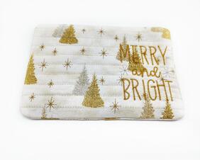 Beige background with silver and gold pine trees and snowflakes, metallic embroidered words.