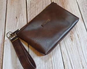 front view of a brown marbled faux leather wristlet with gunmetal hardware and a gunmetal Bass Creations logo.