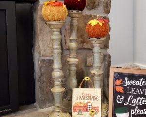 Sweater pumpkin set posed on candlestick holders.