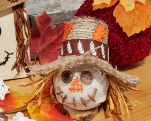 Scarecrow with brown ribbon and orange leaf