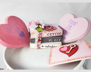 : Book stack with two conversation hearts and a love letter