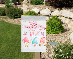 Spring gnome garden flag in a garden landscape