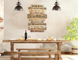 A rustic Family rules wood sign hanging in a dining area of a lodge mountain home. This sign is made up with eleven boards hanging together