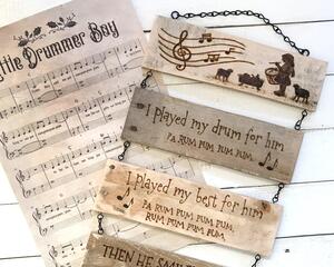 This image shows a handmade Christmas decoration. It is a wood wall hanging featuring the Little Drummer Boy and song lyrics. 