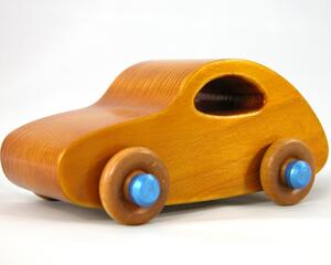 Handmade wooden toy car with an amber shellac finish and metallic sapphire blue trim, modeled after the classic 1957 Bug.