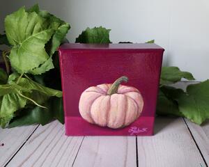 Photo of small square canvas painting of peach colored pumpkin with a raspberry pink background