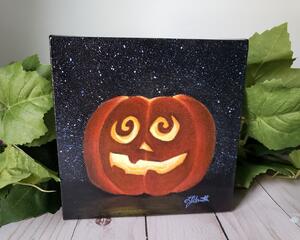 Photo of small square canvas painting of glowing jack o'lantern pumpkin with swirling eyes and a starry sky in the background