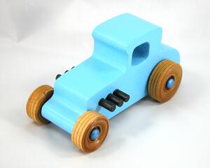 This handmade wooden toy car, modeled after a 1927 Ford T-Coupe, is hand-painted baby blue with black and metallic sapphire blue. The wheels are finished with nonmarring amber shellac.