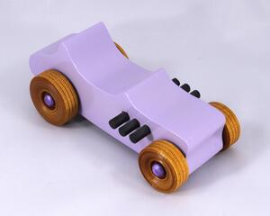 This toy is a beautifully crafted wooden toy car in a '27 T-Bucket Hot Rod style. The car has been painted with a high gloss lavender finish and features black acrylic paint trim. The wheels are non-marring and have an amber shellac finish.
