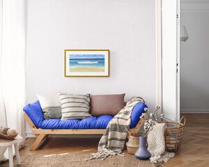 A Day At The Beach Fine Art Print shown on a living room wall with a white border and light stained wood frame.