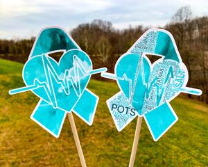The word cloud and watercolor designs are shown on 2 sticks. Both ribbons feature a turquoise awareness ribbon with a heart and heart beat line in the center. The word cloud design on the right is split in half with a word cloud on the left half of the ribbon and heart beat and right half of the heart.