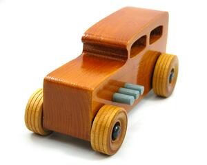 This handmade wooden toy car is based on a 1932 Ford Sedan Hot Rod. It is hand-finished with multiple coats of amber shellac and trimmed with black and grey acrylic paint.