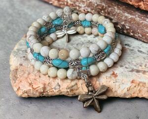White stone and turquoise colored memory wire bracelet with a dragon fly charm.