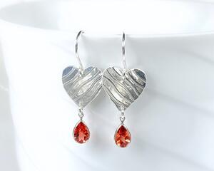 Silver heart earrings with bezel set orange citrine gemstones.