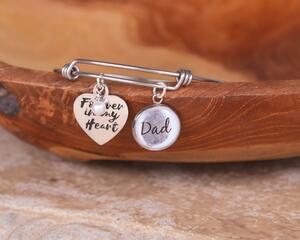 Silver wire bangle bracelet features a custom Dad fingerprint charm, and second heart-shaped Forever in my heart charm with pearl dangle.