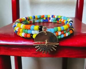 This is handmade festive multi colored beads on memory wire. With a charm,