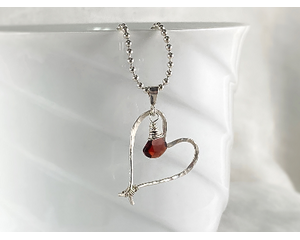 Wire wrapped garnet and sterling silver heart necklace.