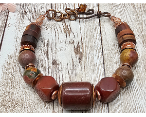 Bracelet is comprised of jasper, tiger eye, and agate with copper accents. The handmade hook clasp allows for some flexibility in length.