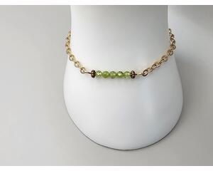 Dainty bracelet comprised of tiny faceted peridots and stainless steel chain with hook clasp handcrafted allowing for flexibility in length.