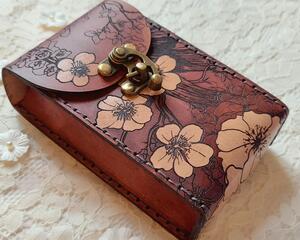This is a Premium Leather Tarot Card Case covered on the front, back bottom and top with cherry blossoms - or Sakura. It's a handmade tarot deck box which has been hand dyed in Mahogany & Natural Tan, and hand stitched in dark graphite grey. There's much to love about this Japanese inspired floral tarot card holder.

This premium leather case is hand dyed in Mahogany and Natural Tan. The mahogany dye produces an antique look with many shades of red tones that wash over the entire case. The natural character of the real full grain leather combined with the hand dying process makes each case unique. Select flowers are highlighted with a natural tan finish which creates a bold contrast against the mahogany background.

Featuring artwork permanently etched into the leather in black:

The Sakura / Cherry Blossom art has been permanently engraved into the leather. The sakura branches and blossoms move completely around the case front to bottom to back to top, creating a wonderful flow and energy about it.