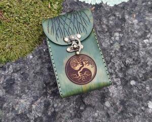 This is a Premium Handmade Leather Tarot Card Case in beautiful shades of green, featuring a Tree of Life Balance symbol on the front. The back of the case features a larger Tree of Life with branches extending over the top and the front flap of the case. This special leather tarot card box was hand dyed and hand sewn in our shop.

Hand crafted from vegetable tanned (naturally tanned) leather. We use full grain leather which retains the full richness and character of the hide. Vegetable tanned leather will develop a wonderful patina with use. The case is designed to last decades and improve with age and use.

This special and unique find would make a beautiful gift for a tarot enthusiast in your life, or anybody looking to protect their tarot cards, oracle decks, or other small items. 

Featuring artwork permanently etched into the leather in black:

The front of this leather case displays the Tree of Life as a balance symbol.
The back of the case features a large Tree of Life with branches which extend over the front.