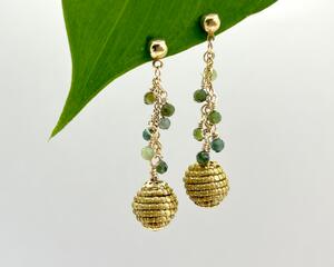 Green tourmaline gems and eco-friendly golden grass bead make these dangle earrings unique and elegant. 2 3/4 long, gold plated.