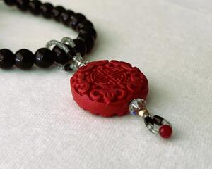 Black beaded necklace with red pendant