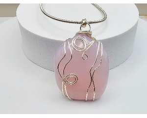 Pink glass pendant, 2 inches long, 1 inch wide, wrapped in silver wire hung on 24 inches of French Bullion stainless steel wire