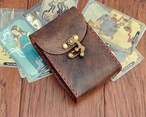 Premium Handmade Leather Tarot Card Case which has been specially sized to fit slightly smaller (palm sized) tarot decks. It's been hand dyed in Antique Black and hand sewn in Dark Red.