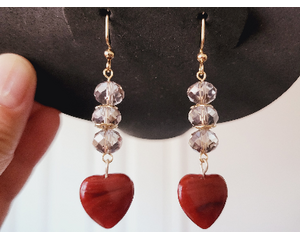 Light Gray Beaded Dangle Earrings with Red Banded Heart Charm dangles on a jewelry display.  The red bands are darker than the charm.