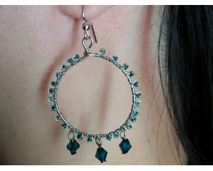Tiny emerald green and clear seed beads wire wrapped on the outer rim of gray hoops. 3 small emerald green diamond shape beads hang on base.