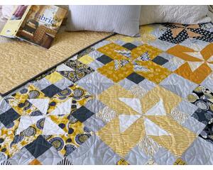 handmade quilt, 56 X 70, shades of yellow and gray; scrappy look with folk-themed prints mixed with solids and stripes; gender neutral