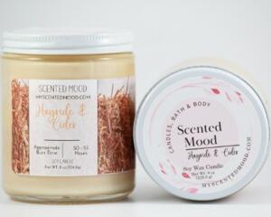 Hayride and cider scented soy candle with hay on the picture. The candle is beige.