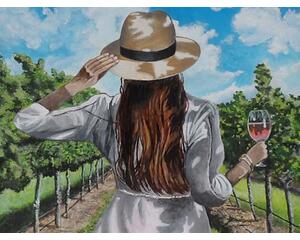 Girl enjoying life having a glass of wine in the field at a winery.