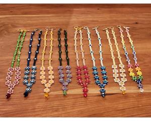 The Whimsy family of necklaces. Left to right: Cherry Blossom, Glacier, Tangerine, Passion Flower, Flame, Ocean, Daisy, and Rainbow