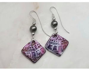 Purple and silver square dangles embossed with geometric shaped imprints hung with silver swarovski pearls. Handcrafted silver earring wires