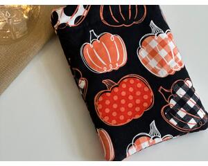 this pumpkin kindle sleeve has a black background with pumpkins having different prints on them
