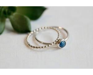 Denim lapis ring with beaded silver band on a wooden surface, showcasing eco-friendly craftsmanship.
