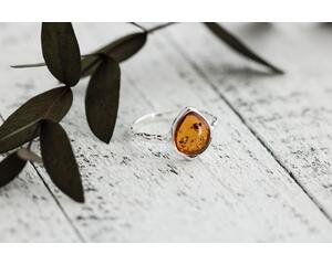 Pear shaped Baltic amber cabochon set on a textured organic band and bezel.