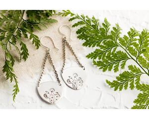 Trillion shaped sterling silver earrings stamped with a floral design hanging from sterling silver chain a French hook ear wire. 