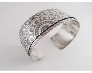 Wide sterling silver bracelet with mandala textured overlay.
