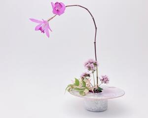 photo of kiln-fired copper enamel ikebana-style vase with hand painted hibiscus on top with is 4 inches in diameter. Enamel colors of hibiscus are pale pink and lavender, with pale green leaves. Vase stands 1-1/4 inch tall. There is a pin-frog inside to hold flowers upright.